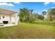 Spacious backyard with green grass, a fence, and a covered patio featuring an outdoor grill at 4216 Jespersen St, Apopka, FL 32712