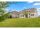 View of backyard and two-story home with lawn, and a neighboring house with a fence, creating a peaceful outdoor space at 4216 Jespersen St, Apopka, FL 32712