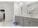 Modern bathroom features double vanity with gray cabinets and quartz counters plus tiled floors at 4216 Jespersen St, Apopka, FL 32712