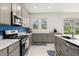 Modern kitchen with gray cabinets, stainless appliances, and lots of countertop space overlooking green yard at 4216 Jespersen St, Apopka, FL 32712