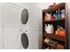 Functional laundry area features stackable washer/dryer and shelving for laundry supplies, maximizing space efficiency at 4216 Jespersen St, Apopka, FL 32712