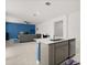Open concept living room adjacent to kitchen with tile floors, lots of natural light, and modern gray furniture at 4216 Jespersen St, Apopka, FL 32712