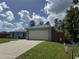 A single-story home with a two-car garage, a well-maintained lawn and a paved driveway on a sunny day at 4382 Sw 171St Pl, Ocala, FL 34473