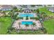 Aerial view of the community pool area, featuring pools, lounge chairs, and palm trees at 439 Sunfish Dr, Winter Haven, FL 33881