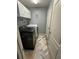 Functional laundry room features a black washing machine, white dryer, white cabinets and tile floors at 439 Sunfish Dr, Winter Haven, FL 33881