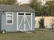 Well-maintained shed with double doors, a ramp, window and neutral paint, in a fenced yard at 439 Sunfish Dr, Winter Haven, FL 33881