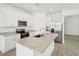 Open kitchen featuring a center island with granite countertops, white cabinets, and stainless appliances at 4545 Cross Prairie Pkwy, St Cloud, FL 34772