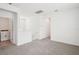 A versatile upstairs loft space with plush carpeting, neutral walls, and a view of the laundry room at 4545 Cross Prairie Pkwy, St Cloud, FL 34772