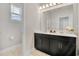 Bathroom featuring double sinks with black cabinets, modern lighting, and neutral wall paint at 4875 Lacewing Dr, Winter Garden, FL 34787
