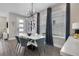 Modern dining room features contemporary lighting, artwork and large windows with custom drapes at 4875 Lacewing Dr, Winter Garden, FL 34787