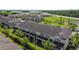 Aerial view of tan townhomes with dark roof, patios, and green space at 509 Artisan St # 43, Orlando, FL 32824