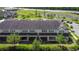 Aerial view of tan townhomes with dark roof, patios, and green space at 509 Artisan St # 43, Orlando, FL 32824