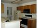 The kitchen has wood cabinets, a white refrigerator, and standard oven and microwave at 5279 Images Cir # 301, Kissimmee, FL 34746