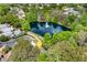 Aerial view of a home in a lush, green neighborhood, overlooking a pond with a fountain at 600 Fallsmead Cir, Longwood, FL 32750