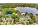 Aerial view of homes nestled by a scenic lake, with a fountain, and lush green spaces at 600 Fallsmead Cir, Longwood, FL 32750