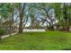 Spacious lawn stretches to waterfront, framed by Spanish moss-draped trees, creating a peaceful, scenic backdrop at 600 Fallsmead Cir, Longwood, FL 32750