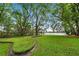 Expansive backyard with lush greenery, mature trees, and a view of the tranquil waterfront at 600 Fallsmead Cir, Longwood, FL 32750