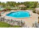 Sparkling community pool with lounge chairs, beautiful landscaping, and a covered patio area at 600 Fallsmead Cir, Longwood, FL 32750