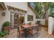 Outdoor patio seating area with a wooden table, grill, and view through sliding glass doors to the home's interior at 600 Fallsmead Cir, Longwood, FL 32750