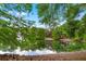 Picturesque pond view with a fountain, lush trees, and a charming gazebo reflecting in the water at 600 Fallsmead Cir, Longwood, FL 32750