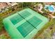 Aerial shot of two tennis courts with benches and lighting, surrounded by palm trees at 600 Fallsmead Cir, Longwood, FL 32750