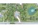 An aerial view shows the home's location in a wooded area near a pond with a fountain feature at 6144 Avenue G, Mc Intosh, FL 32664