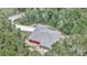 An aerial view of the home showing a durable gray roof and nice wooded location surrounded by Florida trees at 6144 Avenue G, Mc Intosh, FL 32664
