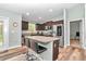 Modern kitchen features stainless steel appliances, dark wood cabinets, and a granite-topped island with seating at 6144 Avenue G, Mc Intosh, FL 32664