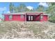 Rear exterior with covered patio featuring ceiling fans, windows, and landscaped yard at 6144 Avenue G, Mc Intosh, FL 32664