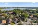 Aerial view of a lakeside community with lush greenery and city skyline in the distance at 7027 Villa Estelle Drive, Orlando, FL 32819