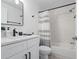 Modern bathroom featuring a white vanity, black hardware, and a shower with a striped curtain at 7027 Villa Estelle Drive, Orlando, FL 32819