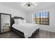 Stylish bedroom with a large window, modern light fixture, and sleek, dark furniture at 7027 Villa Estelle Drive, Orlando, FL 32819