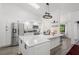 Sun-lit kitchen with white cabinets, stainless steel appliances, a large island, and wood floors at 7027 Villa Estelle Drive, Orlando, FL 32819
