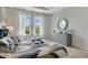 Cozy bedroom with natural light, neutral colors and a decorative mirror above the dresser at 7225 Nottingham Reel Ct, St Cloud, FL 34773