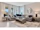 Bright living room with large windows and comfortable gray sectional sofa with throw pillows at 7225 Nottingham Reel Ct, St Cloud, FL 34773