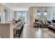 Open-concept living area with breakfast bar seating, neutral decor, and large windows at 7225 Nottingham Reel Ct, St Cloud, FL 34773