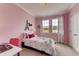 Comfortable bedroom with a pink theme, bright natural light and views of the outdoors at 7237 Nottingham Reel Ct, St Cloud, FL 34773
