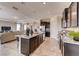 Contemporary kitchen with granite island, dark cabinets, and views to the living area at 7237 Nottingham Reel Ct, St Cloud, FL 34773