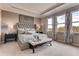 Serene main bedroom featuring a tufted headboard, soft lighting, and large windows at 7237 Nottingham Reel Ct, St Cloud, FL 34773