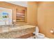 Bathroom featuring a stylish vanity with granite countertop and modern fixtures at 7645 Recife Dr, Kissimmee, FL 34747