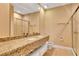 Bright bathroom boasts a double sink vanity with granite countertop and glass-enclosed shower at 7645 Recife Dr, Kissimmee, FL 34747