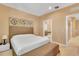 Comfortable bedroom features a queen bed, decorative wall art, and an ensuite bathroom at 7645 Recife Dr, Kissimmee, FL 34747