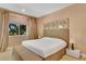 Comfortable bedroom features a queen bed, decorative wall art, and a bench for added comfort at 7645 Recife Dr, Kissimmee, FL 34747