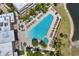 Stunning aerial view of the community pool and tanning deck with ample lounge seating and shade umbrellas at 7645 Recife Dr, Kissimmee, FL 34747