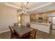 Kitchen and dining area feature wood floors, modern chandelier, and stainless appliances at 810 Greybull Run, Lake Mary, FL 32746