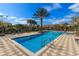 Community pool surrounded by palm trees and lounge chairs on a sunny day at 810 Greybull Run, Lake Mary, FL 32746