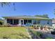 An eye-level view of a patio set, along with lush landscaping and a screened-in enclosure at 827 Princeton Dr, Clermont, FL 34711