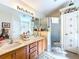 Spacious bathroom showcasing a shower with glass door, cabinets, and a large mirror at 827 Princeton Dr, Clermont, FL 34711
