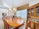 Warm dining room with a wooden table, upholstered chairs, chandelier, and a large window with patterned valance at 827 Princeton Dr, Clermont, FL 34711