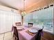 Dining room table with four chairs, large window with blind, and view to the back yard at 827 Princeton Dr, Clermont, FL 34711